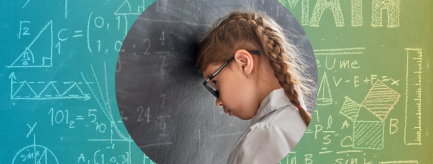 A young girl with glasses leans her head against a blackboard filled with Maths equations, symbolising anxiety and frustration towards learning Maths